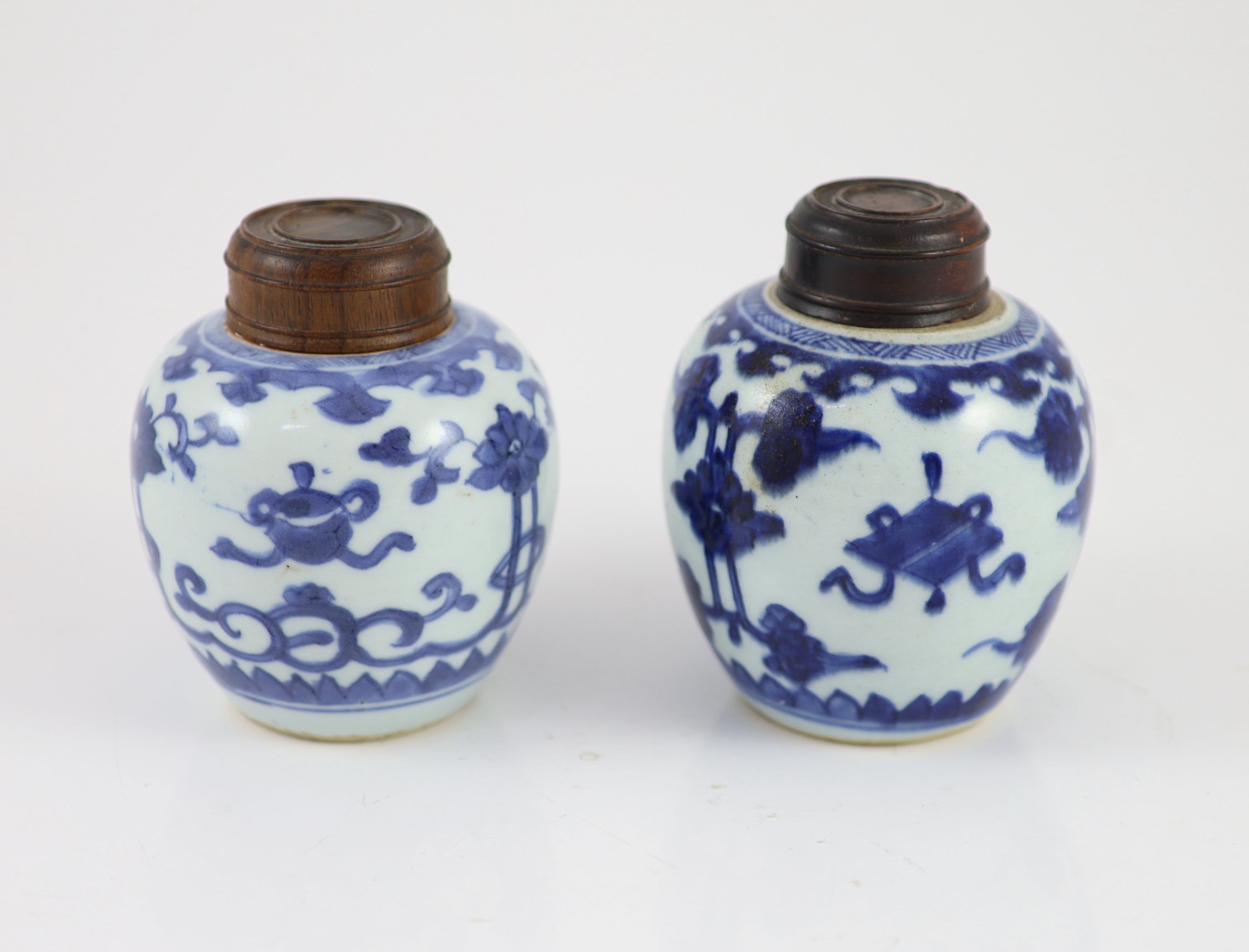 A near pair of Chinese blue and white ovoid jars, Kangxi period, 10 cm high, wood covers